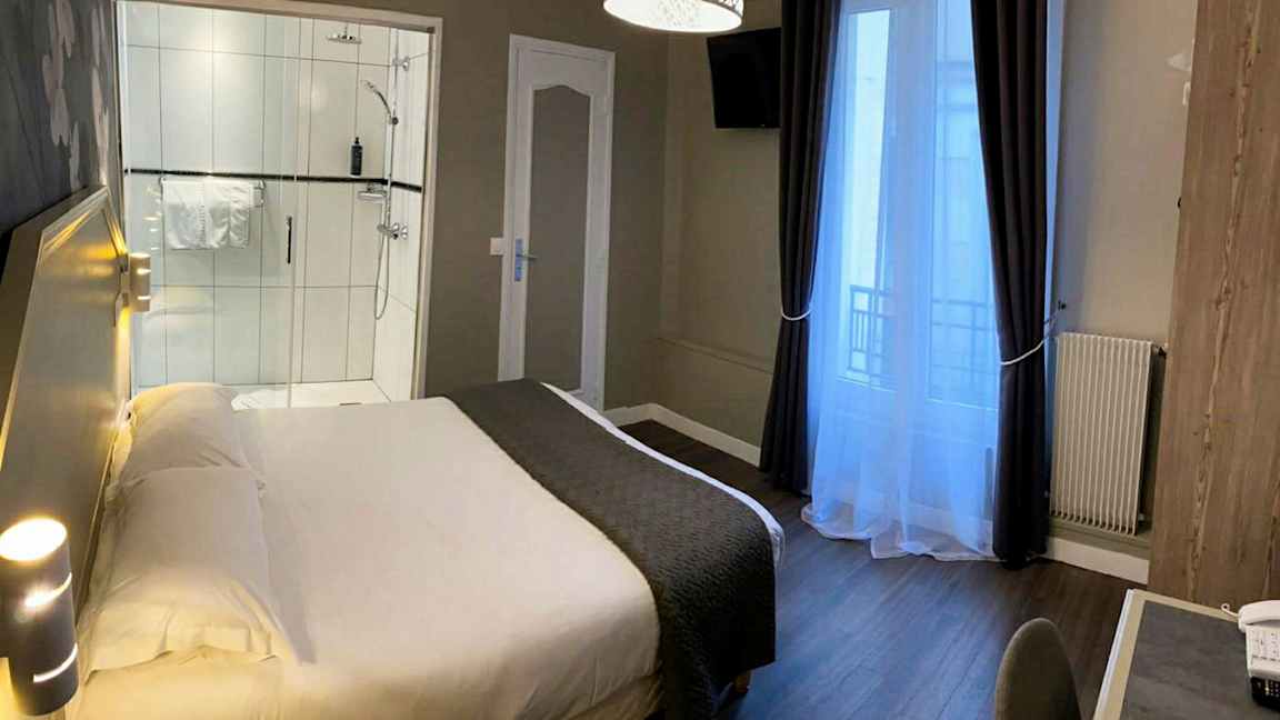 Et hotellrom med en seng, et skrivebord og en dusj. (AI-generert tekst)