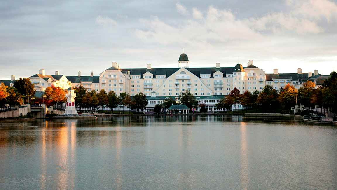 Hotellbygningen ved en innsjø med et lite fyrtårn. (AI-generert tekst)