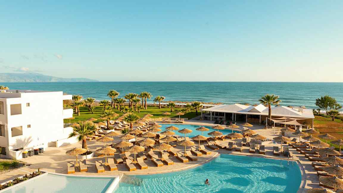 Bassengområde med solsenger og parasoller, med utsikt over havet. (AI-generert tekst)