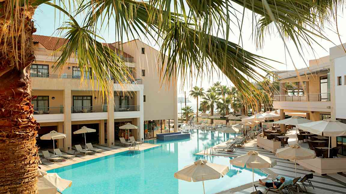 Hotell med utendørsbasseng, solsenger og parasoller. (AI-generert tekst)