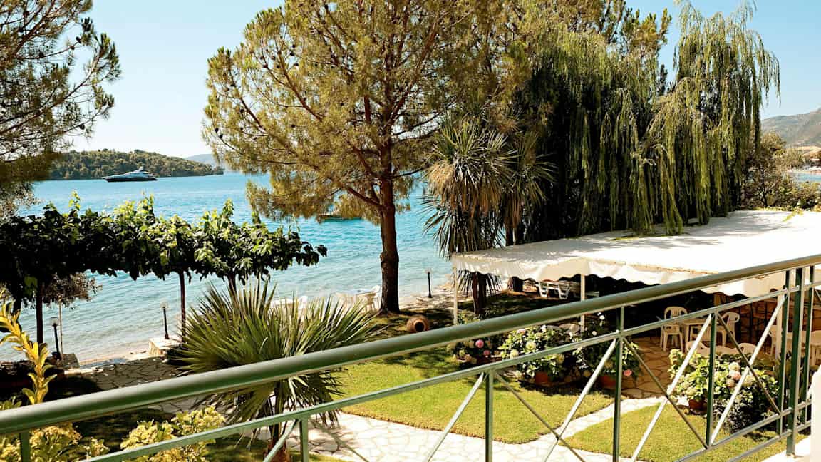 Utsikt over en hage med frodige planter, trær og havet i bakgrunnen. (AI-generert tekst)