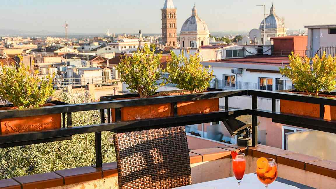 En terrasse med bord, stoler og utsikt over byen med kirketårn. (AI-generert tekst)