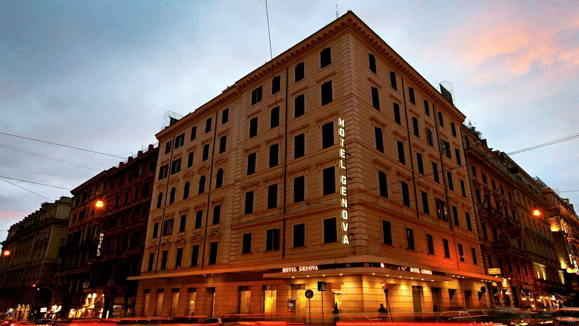 En fleretasjes bygning med teksten Hotel Genova som lyser på fasaden. (AI-generert tekst)
