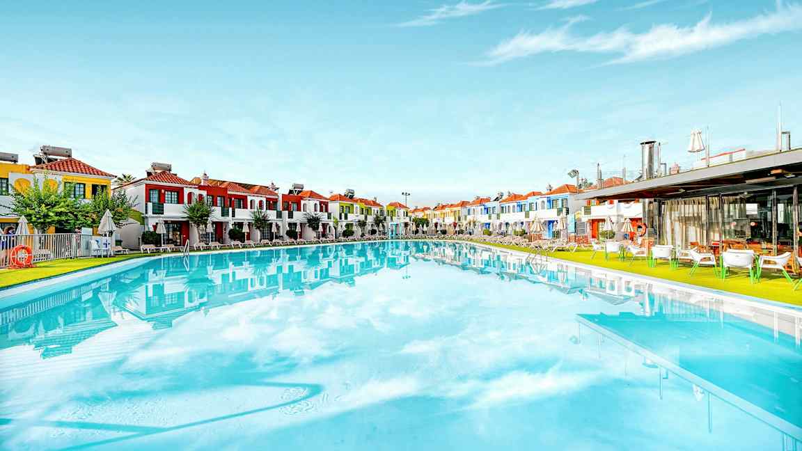 Stor basseng med fargerike bygninger i bakgrunnen. (AI-generert tekst)