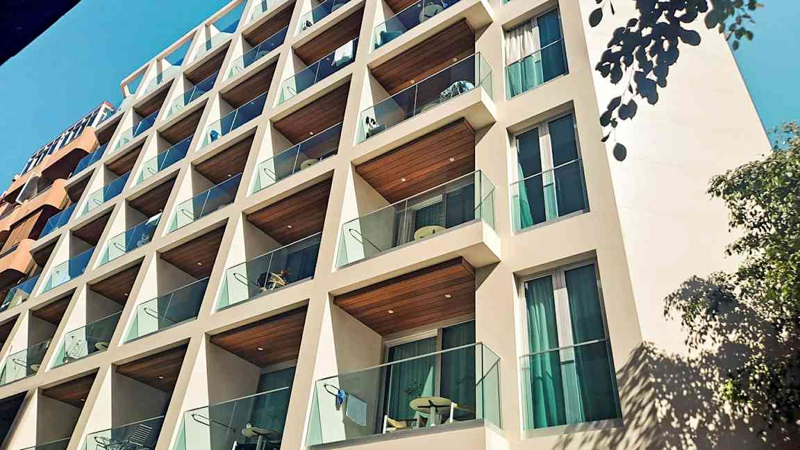 En bygning med balkonger og glassrekkverk. (AI-generert tekst)