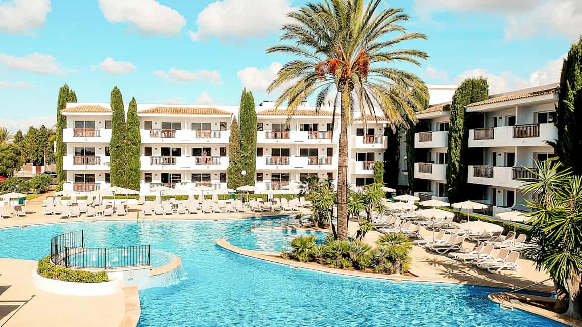 Bilde av hotellområde med basseng og solsenger. (AI-generert tekst)