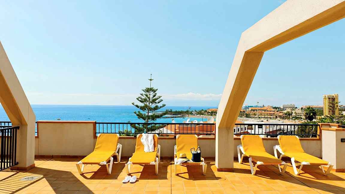 Terrasse med solsenger og havutsikt. (AI-generert tekst)