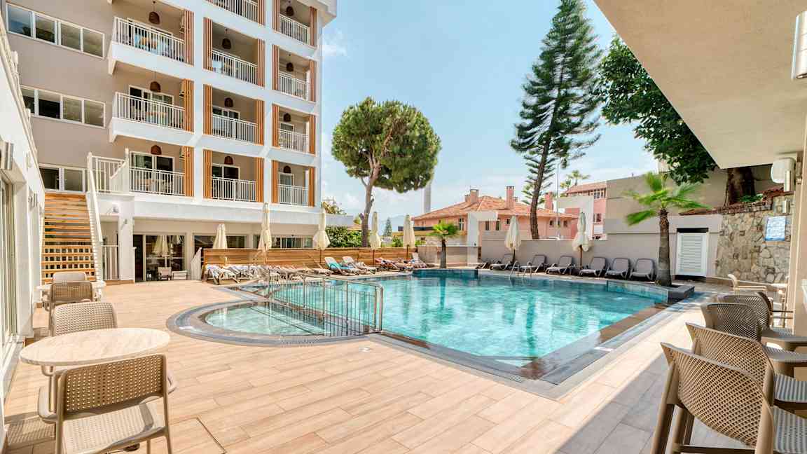 Hotellets utendørsbasseng med sittemøbler og solsenger. (AI-generert tekst)