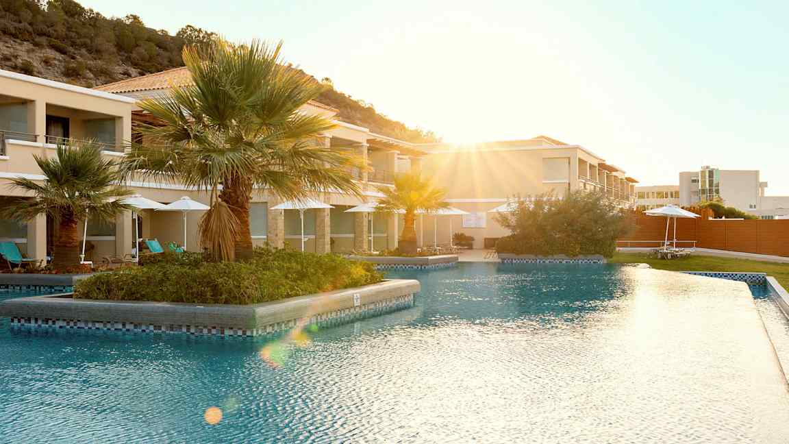 Utendørsbasseng på en resort med palmer i bakgrunnen. (AI-generert tekst)