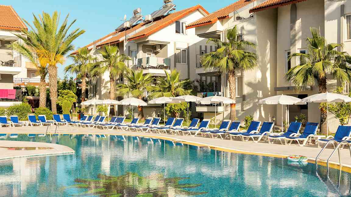 Utendørs svømmebasseng ved hotell med solsenger og parasoller. (AI-generert tekst)