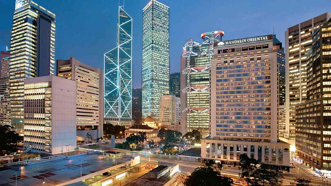 Byutsikt med høye bygninger opplyst i kveldslys. (AI-generert tekst)