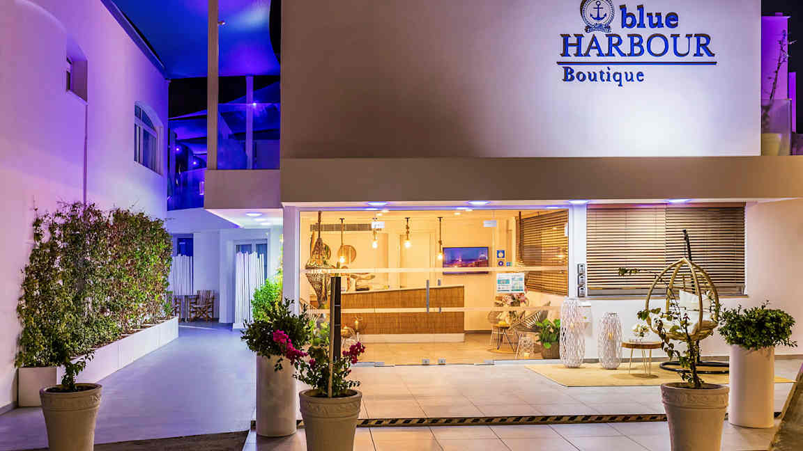 Hotellinngang om natten med vinduer og interiør synlig. (AI-generert tekst)