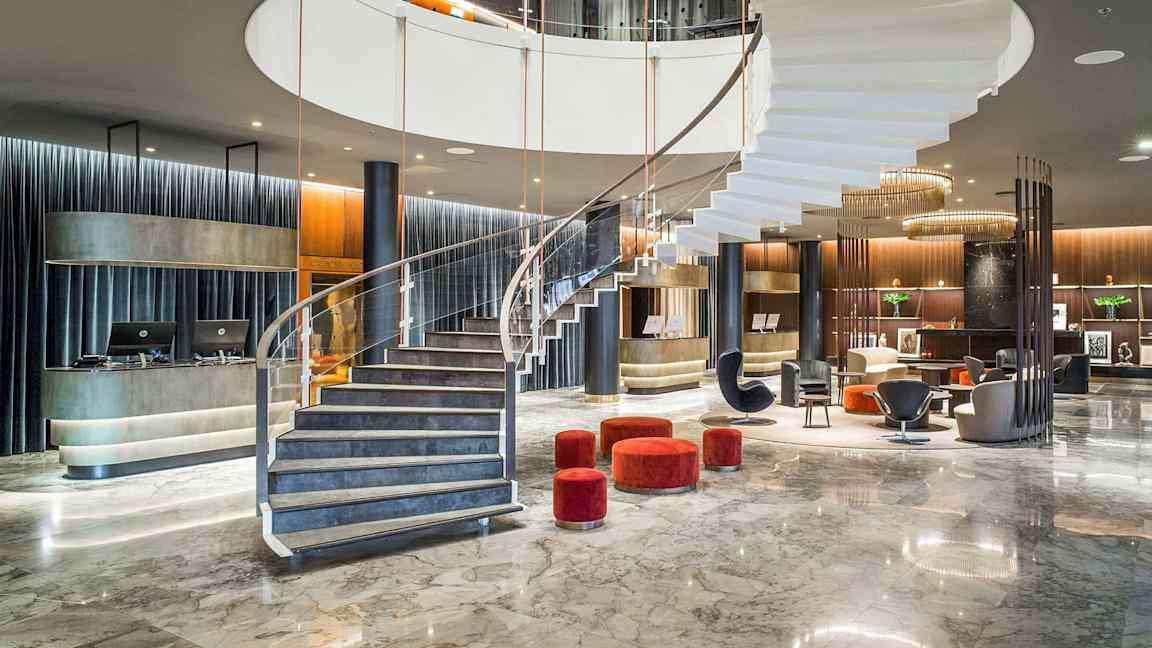 Moderne hotellfoajé med en spiraltrapp og sitteområder. (AI-generert tekst)