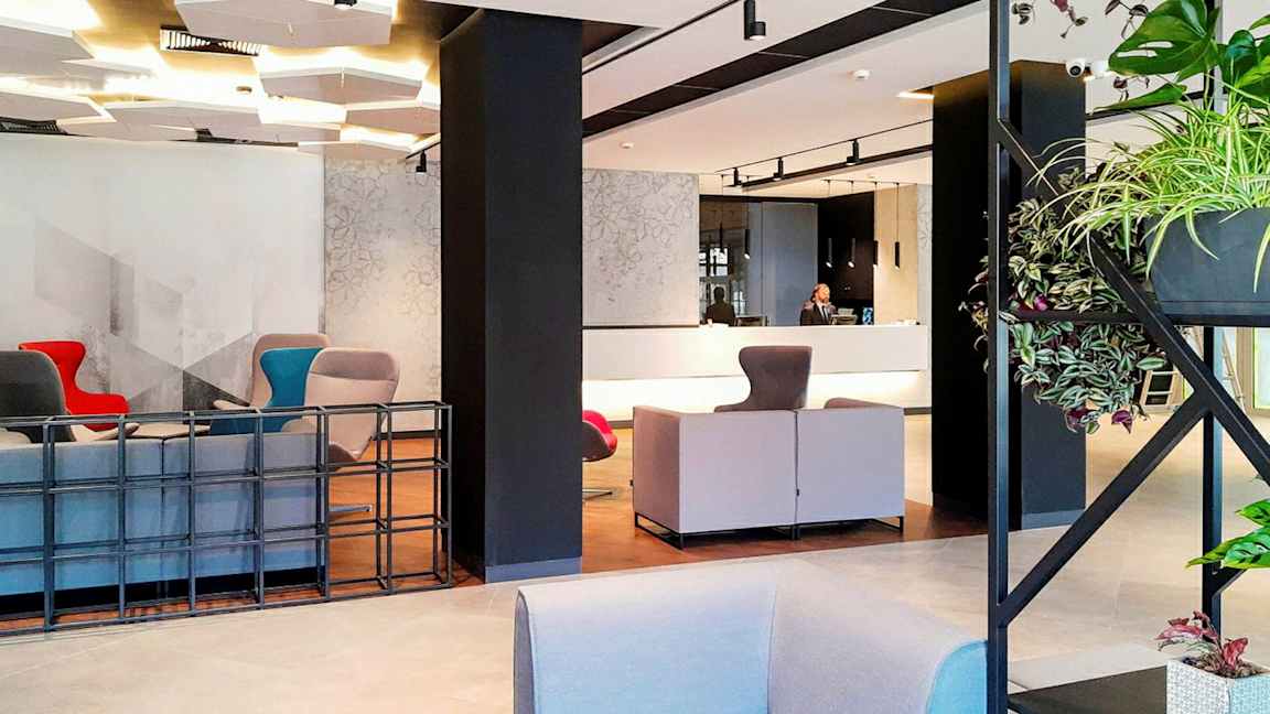Moderne hotellobby med sittegrupper og resepsjon. (AI-generert tekst)