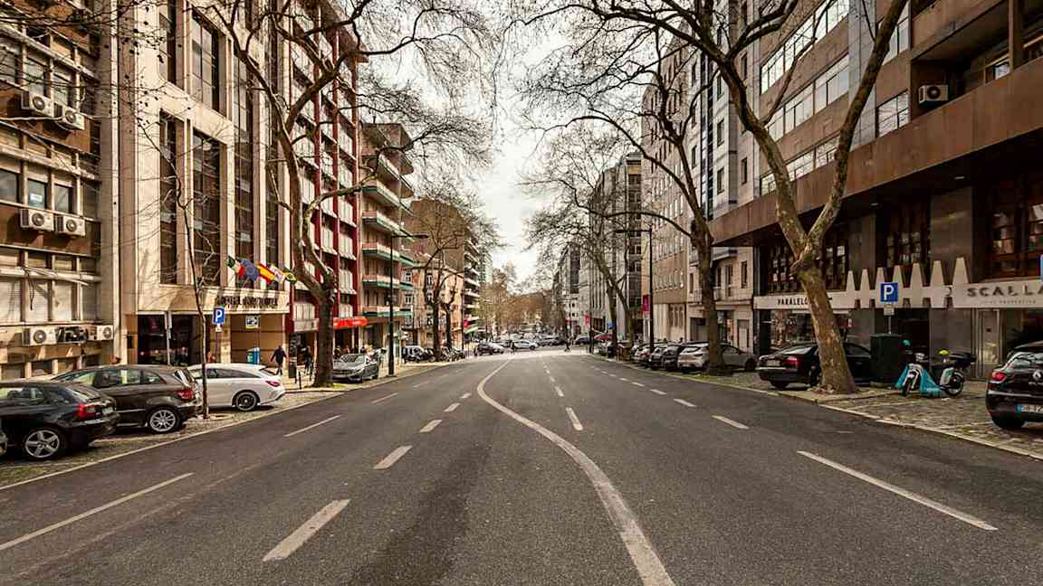 Et bilde av en tom bygate omgitt av bygninger og trær. (AI-generert tekst)