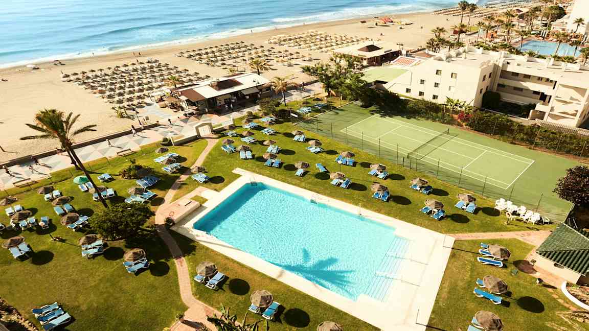 Hotellbassengområdet med utsikt over stranden og havet. (AI-generert tekst)