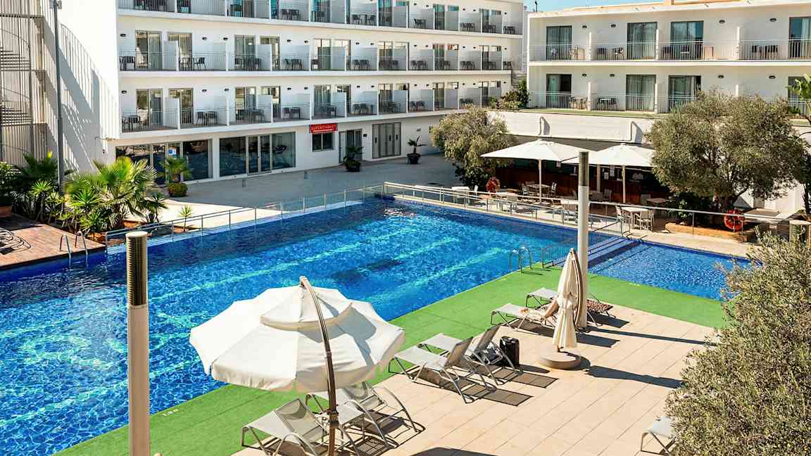 Bilde av en hotellbygning med flere etasjer. Foran bygningen er det et stort basseng og solsenger under parasoller. (AI-generert tekst)