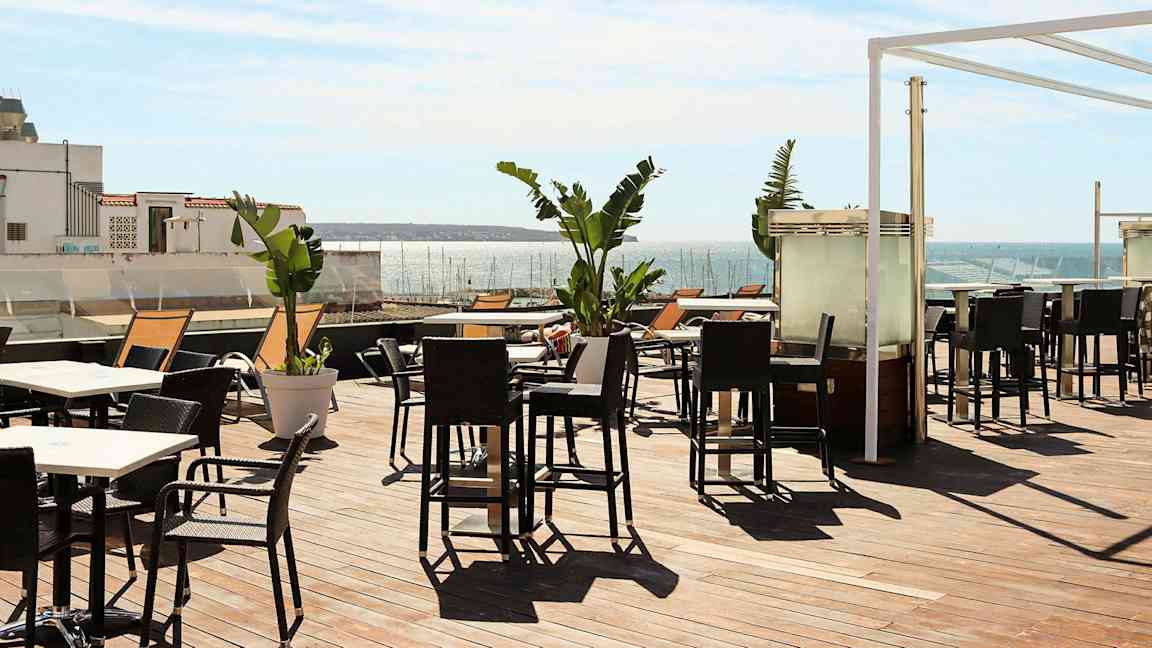 Terrasse med utemøbler og utsikt over havet. (AI-generert tekst)