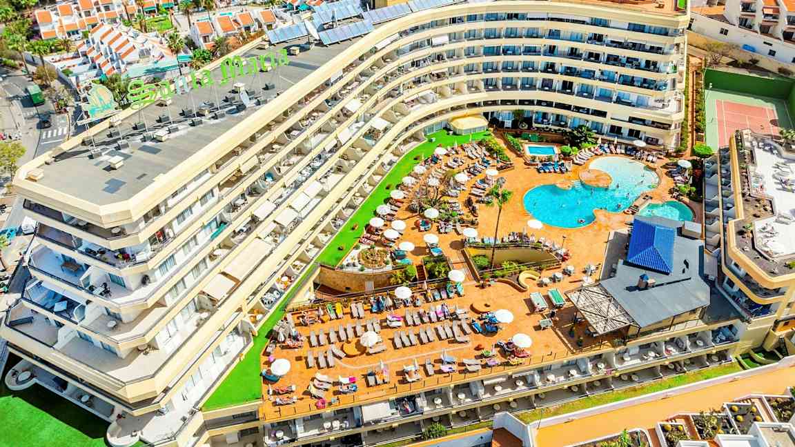 Bilde av et hotell med bassengområde og omkringliggende ferieboliger. (AI-generert tekst)