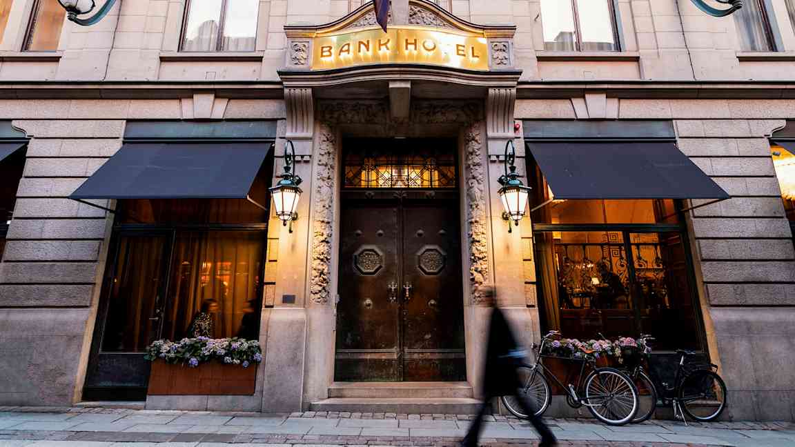 Bygningsfasade med inngangen til Bank Hotel, tydelige detaljer og belysning. (AI-generert tekst)