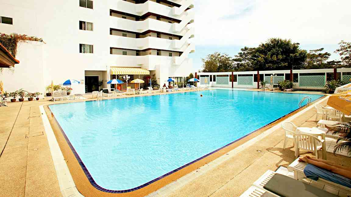 Utendørs basseng ved et hotell med solsenger og parasoller. (AI-generert tekst)