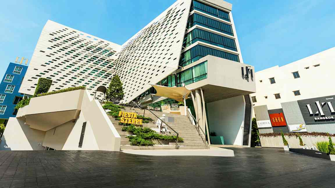 Moderne bygning med unik arkitektur, store glasspartier og en skrå fasade. (AI-generert tekst)