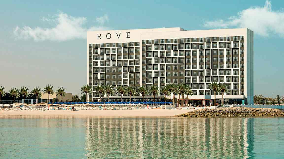 Et hotell ved en strand med palmer. (AI-generert tekst)