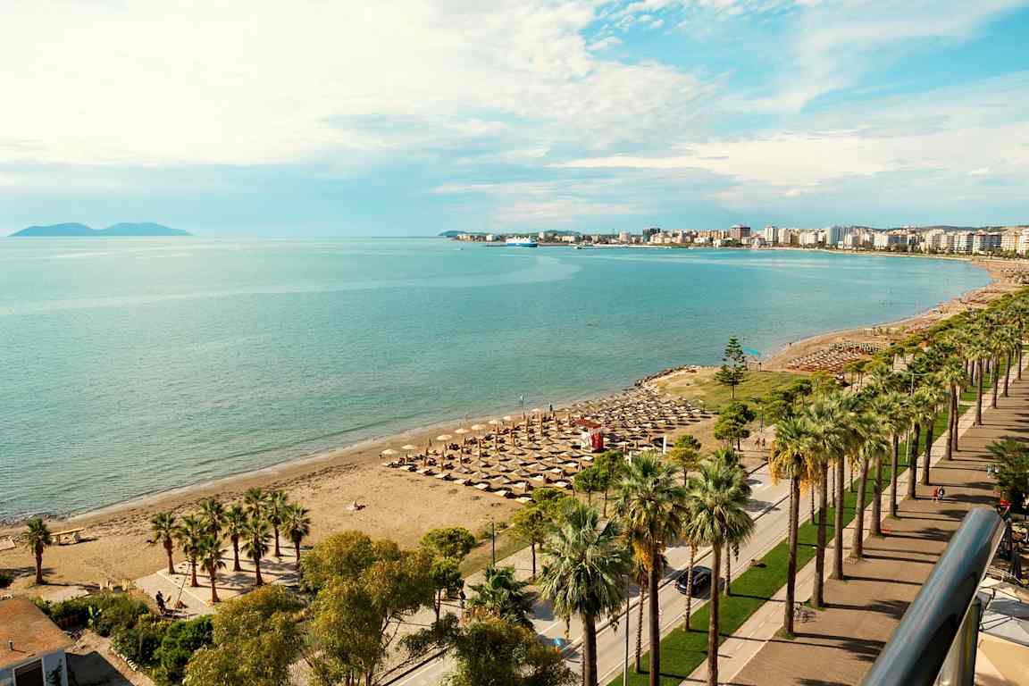 Strand med parasoller og havet i bakgrunnen. (AI-generert tekst)