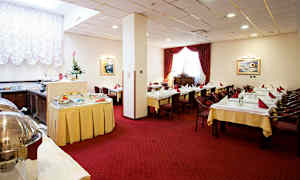 Interiør av en spisesal med oppsatte bord, røde gardiner og en buffé. (AI-generert tekst)