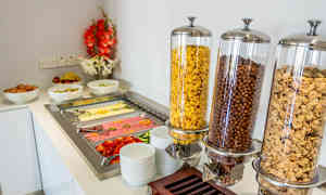 En frokostbuffet med boller av frokostblandinger, egg, frukt og kald mat. (AI-generert tekst)