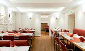 Restaurant med dekkede bord og røde stoler. (AI-generert tekst)