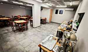 En spisesal med trestoler og bord samt en buffet med serveringsutstyr. (AI-generert tekst)