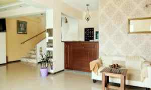 Lys resepsjonområde med sofa, trebord og marmorerte trapp. (AI-generert tekst)