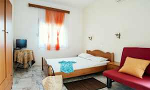 Bilde av et hotellrom med enkeltseng, rød sofa og små møbler. (AI-generert tekst)