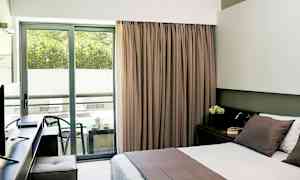 Hotellrom med dobbeltseng og balkong med sittemøbler. (AI-generert tekst)