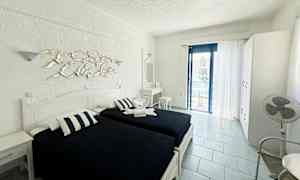 Rom med to enkeltsenger, hvitt interiør og en balkong med havutsikt. (AI-generert tekst)