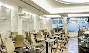 Bilde av en moderne restaurant med marmorgulv, dekkede bord og beige stoler. (AI-generert tekst)