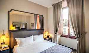 Hotellrom med dobbeltseng, nattbord, speil og vindu med beige gardiner. (AI-generert tekst)