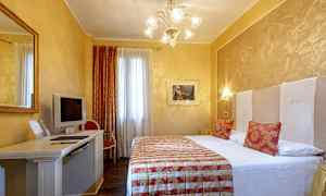 Et hotellrom med en dobbeltseng, skrivebord med en TV og stol, og dekorative elementer. (AI-generert tekst)