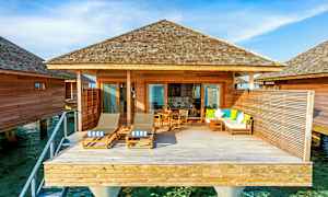 En overwater-bungalow med treterrasse og sittemøbler. (AI-generert tekst)
