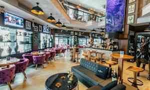 En innbydende bar med moderne møbler og dekorative elementer som kunstverk og skulpturer. (AI-generert tekst)