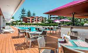 Utendørsområde med basseng, solsenger og et serveringsområde. (AI-generert tekst)