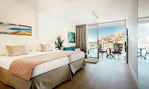 Dobbeltrom med lys innredning og balkong med utsikt. (AI-generert tekst)