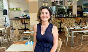 Restaurant med oppstilte bord og stoler samt en bardisk i bakgrunnen. (AI-generert tekst)