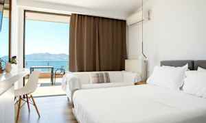 Lyst hotellrom med dobbeltseng og balkong med havutsikt. (AI-generert tekst)