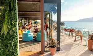 En solrik terrasse med sittemøbler og havutsikt. (AI-generert tekst)