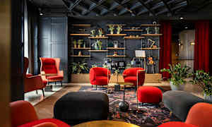 Elegant lounge med røde og svarte møbler, planter og en hylle med dekorative gjenstander. (AI-generert tekst)