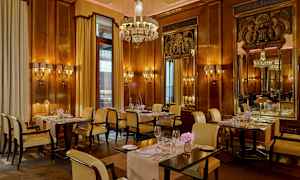 Restaurant med elegant interiør, vegger med trepanel, lysekrone og dekkede bord. (AI-generert tekst)