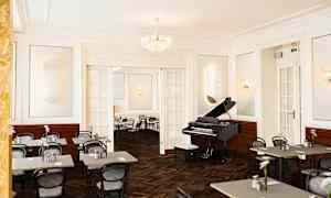 Et elegant innredet rom med et piano og oppstilte kafébord og stoler. (AI-generert tekst)