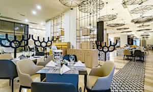 En moderne restaurant med elegante møbler og en stilfull tak. (AI-generert tekst)